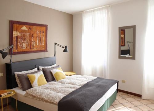 - une chambre avec un grand lit et des oreillers jaunes dans l'établissement Casa San Giacomo 1, à Riva del Garda