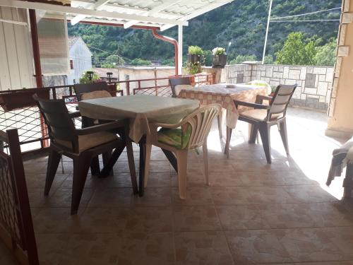 a patio with tables and chairs on a balcony at Room at Grandma's Fatima in Stolac