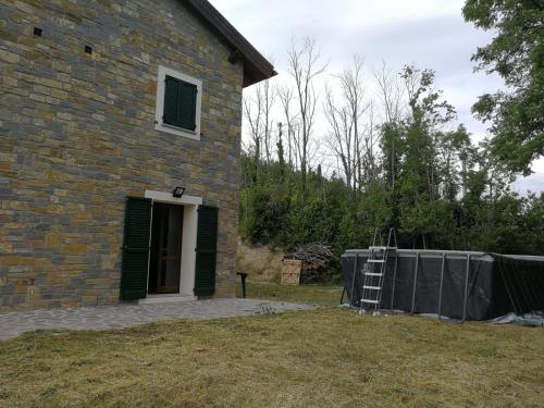 a brick house with a ladder in front of it at Villa Viktoria & Andras in Tredozio