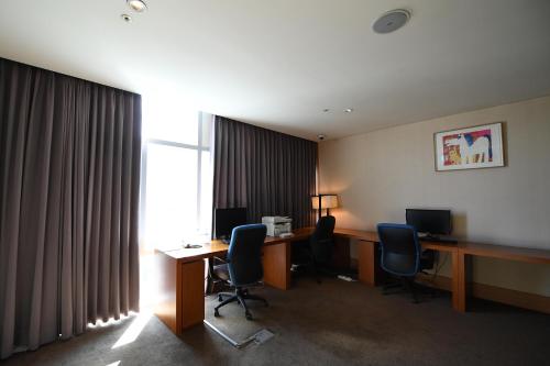 an office with a desk and chairs and a window at Hotel Laonzena in Daegu