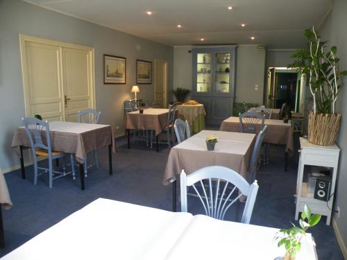 a dining room with tables and chairs and tablesearcher at Hôtel de L'Avenue in Saintes