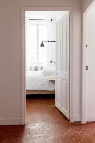 an open door to a bedroom with a bed and a window at Le Pont de L'orme in Malaucène