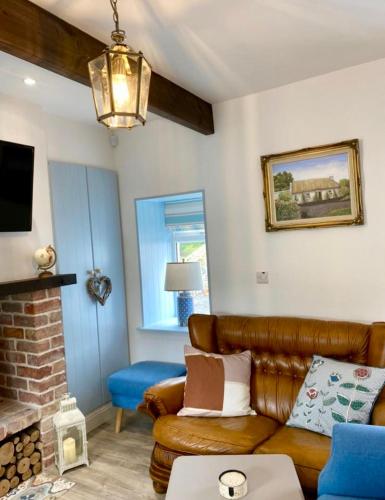 a living room with a couch and a fireplace at Toddys Cottage & Stables in Cavan