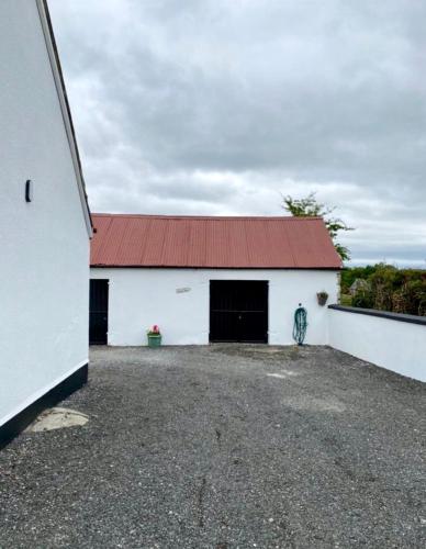 a large white building with a red roof at Toddys Cottage & Stables in Cavan