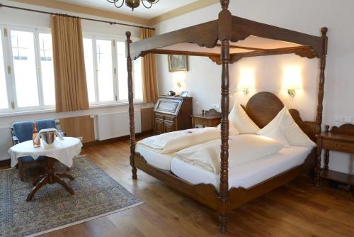 ディンケルスビュールにあるホテル ドイツ ハウスのベッドルーム(天蓋付きベッド1台、テーブル付)