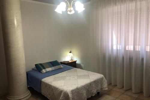 um quarto com uma cama e uma janela com cortinas em Ampio attico a 5 minuti dal mare em San Benedetto del Tronto
