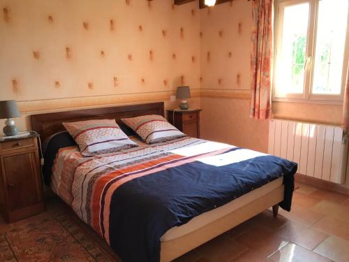 una camera con un letto in una stanza con una finestra di l'Ecrin au coeur des vignes a Saint-Georges-sur-Cher
