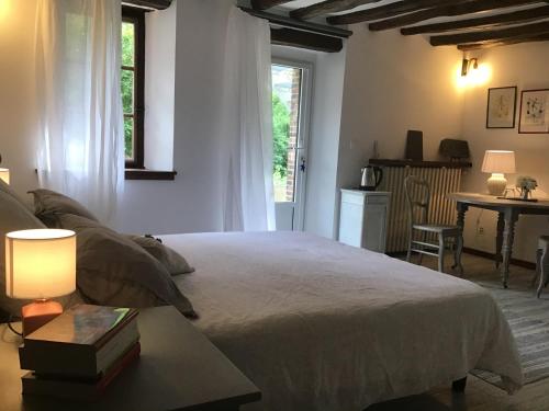 sypialnia z łóżkiem, stołem i oknem w obiekcie La Vigne w mieście Saint-Jean-de-Rebervilliers