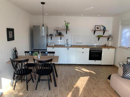 kuchnia i salon ze stołem i krzesłami w obiekcie House Damić w Korčuli