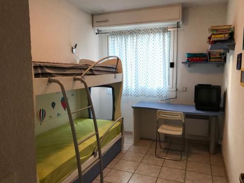 Cette petite chambre comprend des lits superposés et un bureau. dans l'établissement Sun&Sea Terrace Two-Bedroom Apartment, à Roquebrune-Cap-Martin