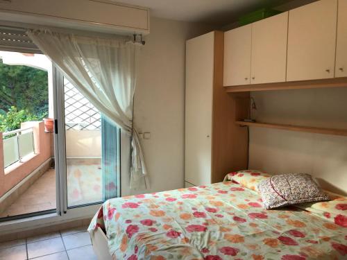 une chambre avec un lit et une grande fenêtre dans l'établissement Sun&Sea Terrace Two-Bedroom Apartment, à Roquebrune-Cap-Martin