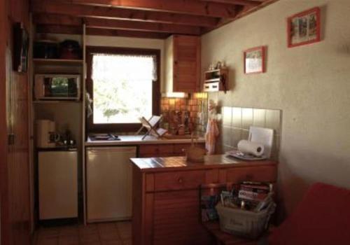 a kitchen with a counter and a refrigerator and a window at Maison à 200 m de la mer in Piriac-sur-Mer