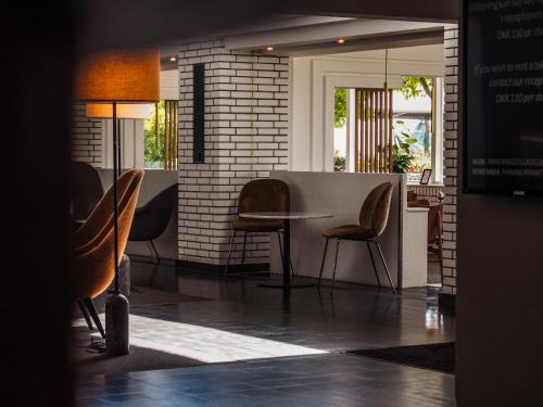 a dining room with chairs and a table in a room at Hotel Marina in Vedbæk