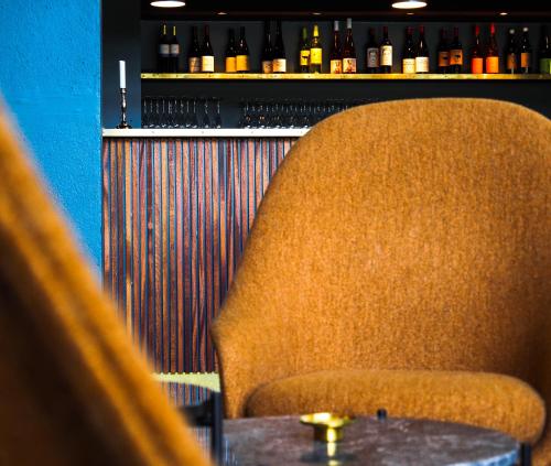 a table and a chair in a bar with bottles at Hotel Marina in Vedbæk