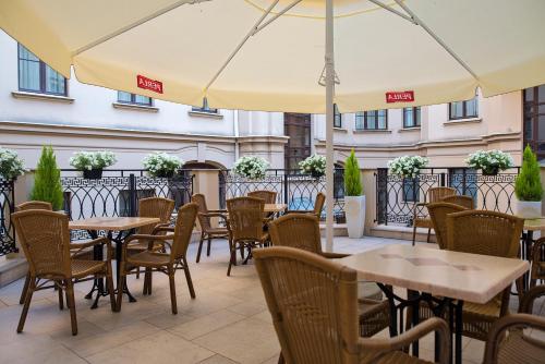 an outdoor patio with tables and chairs and umbrellas at IBB Hotel Grand Hotel Lublin in Lublin