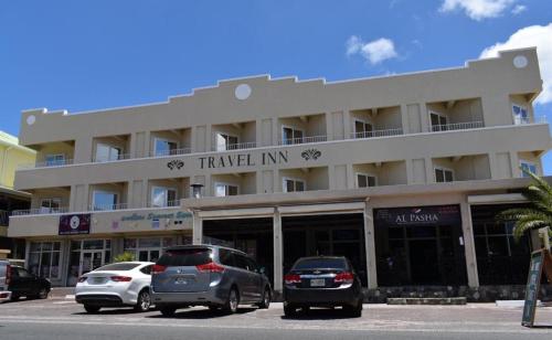 a parking lot with cars parked in front of a building at Travel Inn Hotel Simpson Bay in Simpson Bay