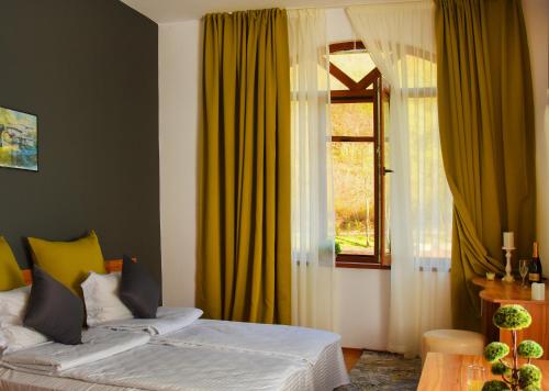 a bedroom with a bed with yellow curtains and a window at Eco Complex Izvori in Varna City