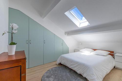 - une chambre blanche avec un lit et une lucarne dans l'établissement 7 DELOYE - Charmant 2 pieces rénové - Dernier étage - Clim, à Nice