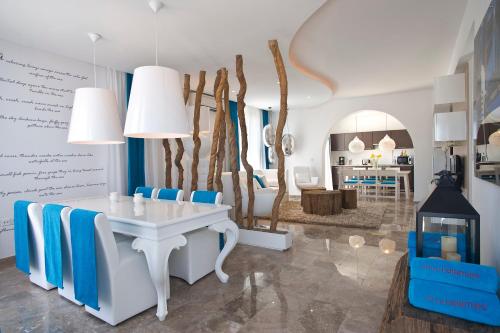 a living room with a white table and blue chairs at Althea Kalamies Luxury Villas in Protaras