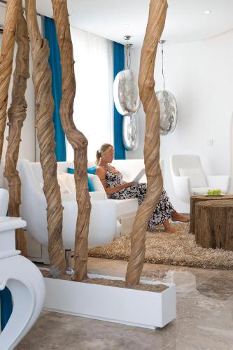 a woman sitting on a couch in a living room at Althea Kalamies Luxury Villas in Protaras