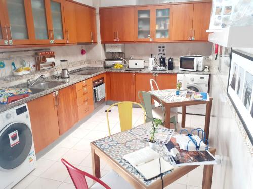 a kitchen with wooden cabinets and a table and chairs at Aveiro Central Its ALL there Apartment in Aveiro