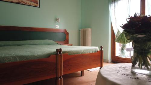 sypialnia z łóżkiem i stołem z wazonem kwiatów w obiekcie Hotel Cristina w mieście Verrayes