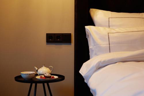 a table with a tea pot on it next to a bed at hotel friends Essen Zeche Zollverein in Essen