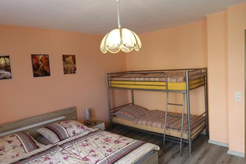 two bunk beds in a room with a chandelier at Haus Lila Welle in Nordhalben