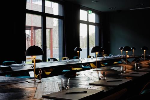 a room with long tables with lamps on them at hotel friends Essen Zeche Zollverein in Essen