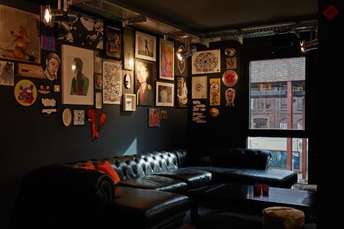 a living room with a leather couch and pictures on the wall at hotel friends Essen Zeche Zollverein in Essen