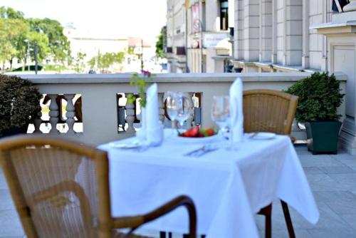 a table with glasses and a bowl of fruit on a balcony at IBB Hotel Grand Hotel Lublin in Lublin
