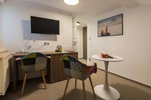 a hotel room with two chairs and a table at Resort Mezná in Hřensko