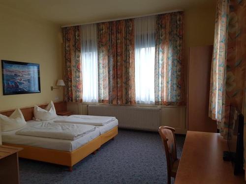 a hotel room with two beds and a window at Traube Hotel Oeffingen in Fellbach