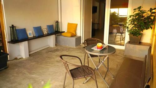 a room with a table and two chairs and a table with a candle at New seafront studio in Anavissos