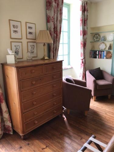 a living room with a dresser and a chair at Chambres d'Hôtes Belle Vallee in Domfront