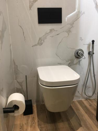 a bathroom with a toilet and a tv on the wall at Ria Studios in Olhão