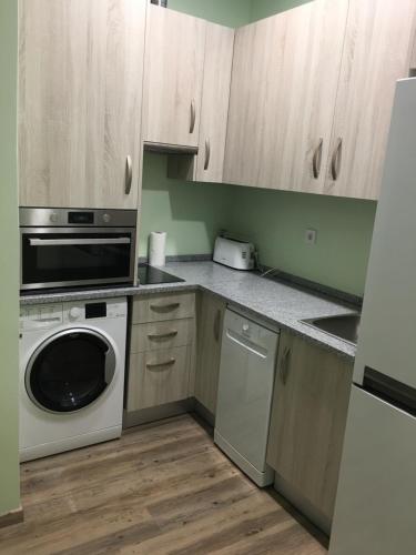 a kitchen with a microwave and a dishwasher at Ria Studios in Olhão
