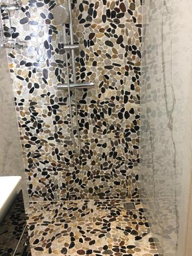 a bathroom with a shower with a mosaic tile floor at Ria Studios in Olhão