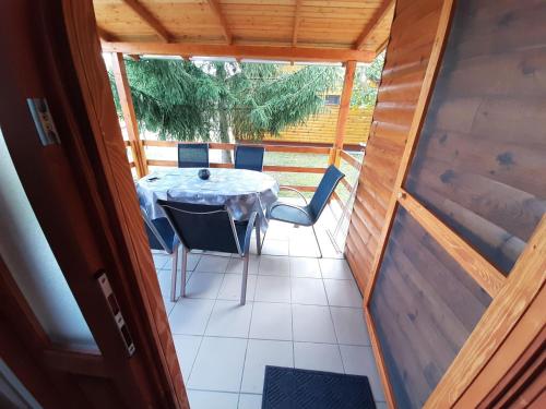 a table and chairs on the porch of a house at Fortuna Apartmanházak in Bogács