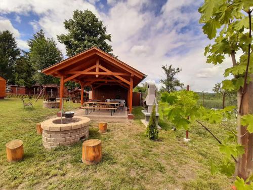 a gazebo with a picnic table and a grill at Fortuna Apartmanházak in Bogács