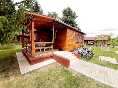 a small cabin with a motorcycle parked in the grass at Fortuna Apartmanházak in Bogács