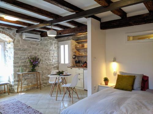 een slaapkamer met een bed en een tafel en een keuken bij Best view! Rooftop with Garden - Old Town Nr404 in Kotor