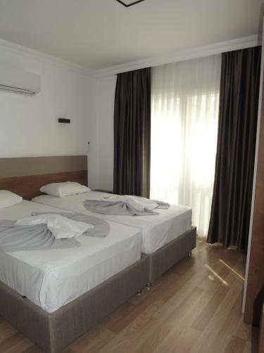 two beds in a bedroom with a window at Opus Apart Hotel in Kusadası