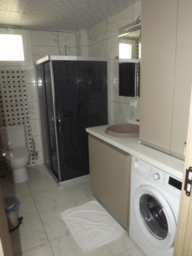 a bathroom with a washing machine and a sink at Opus Apart Hotel in Kusadası