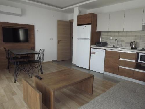 a living room with a table and a kitchen at Opus Apart Hotel in Kusadası