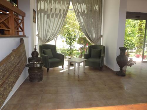 a living room with two chairs and a table at Opus Apart Hotel in Kusadası