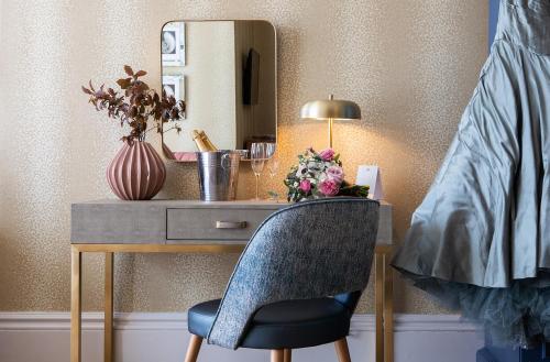 a desk with a chair and a mirror at Queens Hotel & Spa Bournemouth in Bournemouth