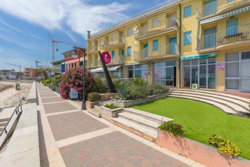 a street in front of a building with a lawn at APARTMENTS GASSER - Apartment 2 in Caorle