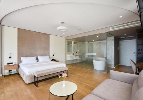a bedroom with a bed and a living room at Yacht Hotel in Vlorë