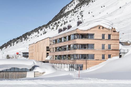 a building on the side of a snow covered mountain at Hotel Jagdschloss Resort in Kühtai